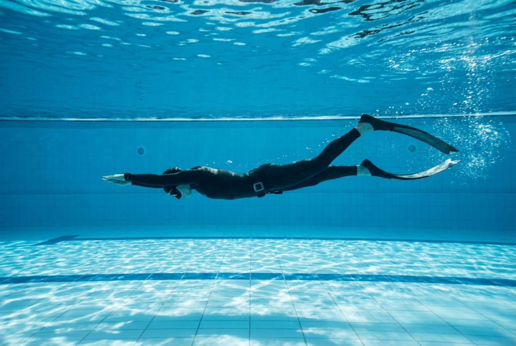 غواص حر يسبح أفقيًا تحت الماء باستخدام الزعانف بكفاءة عالية