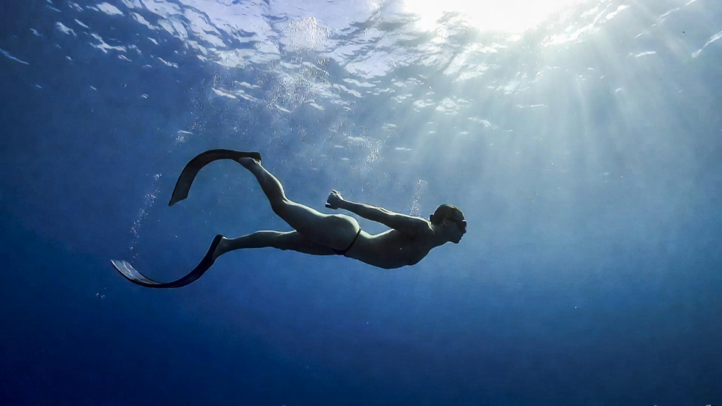 غواص حر يمارس تمرين الأبنيا الساكنة تحت الماء في محيط هادئ