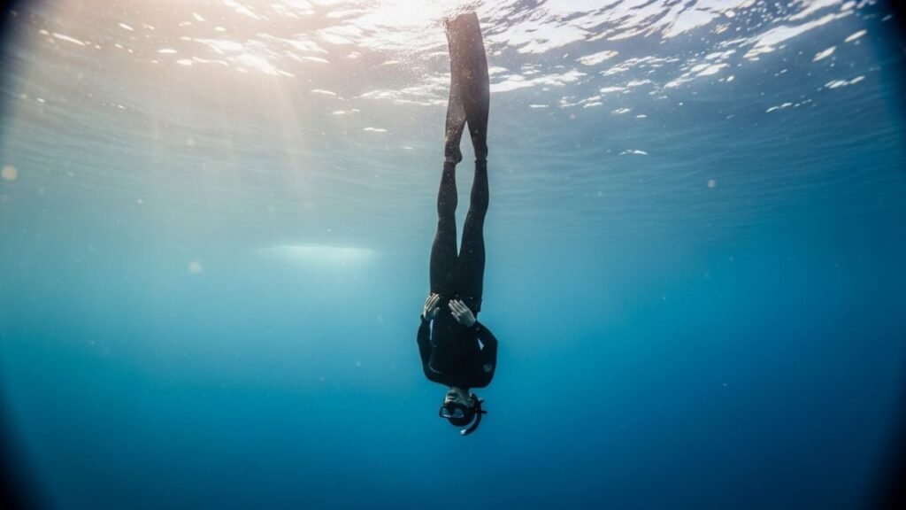 غواص حر يهبط في وضع السقوط الحر دون حركة داخل عمق البحر