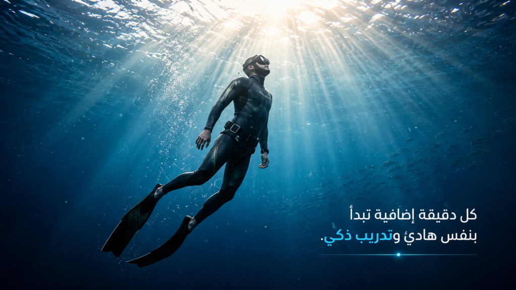 غواص حر يصعد بهدوء نحو الضوء تحت سطح البحر، بينما تخترق أشعة الشمس المياه الزرقاء العميقة وتحيط به فقاعات دقيقة وسرب أسماك بعيد، في مشهد يرمز إلى التقدم والثقة والتحكم في حبس النفس أثناء الغوص الحر.